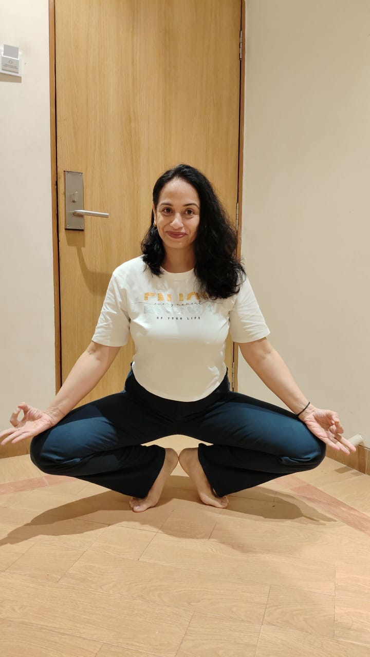 Sneha in a balanced yoga squat